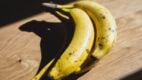 Dve zrele banane na drvenom stolu — namirnica za koju mnogi veruju da je zdrava, ali može izazvati haos u telu.