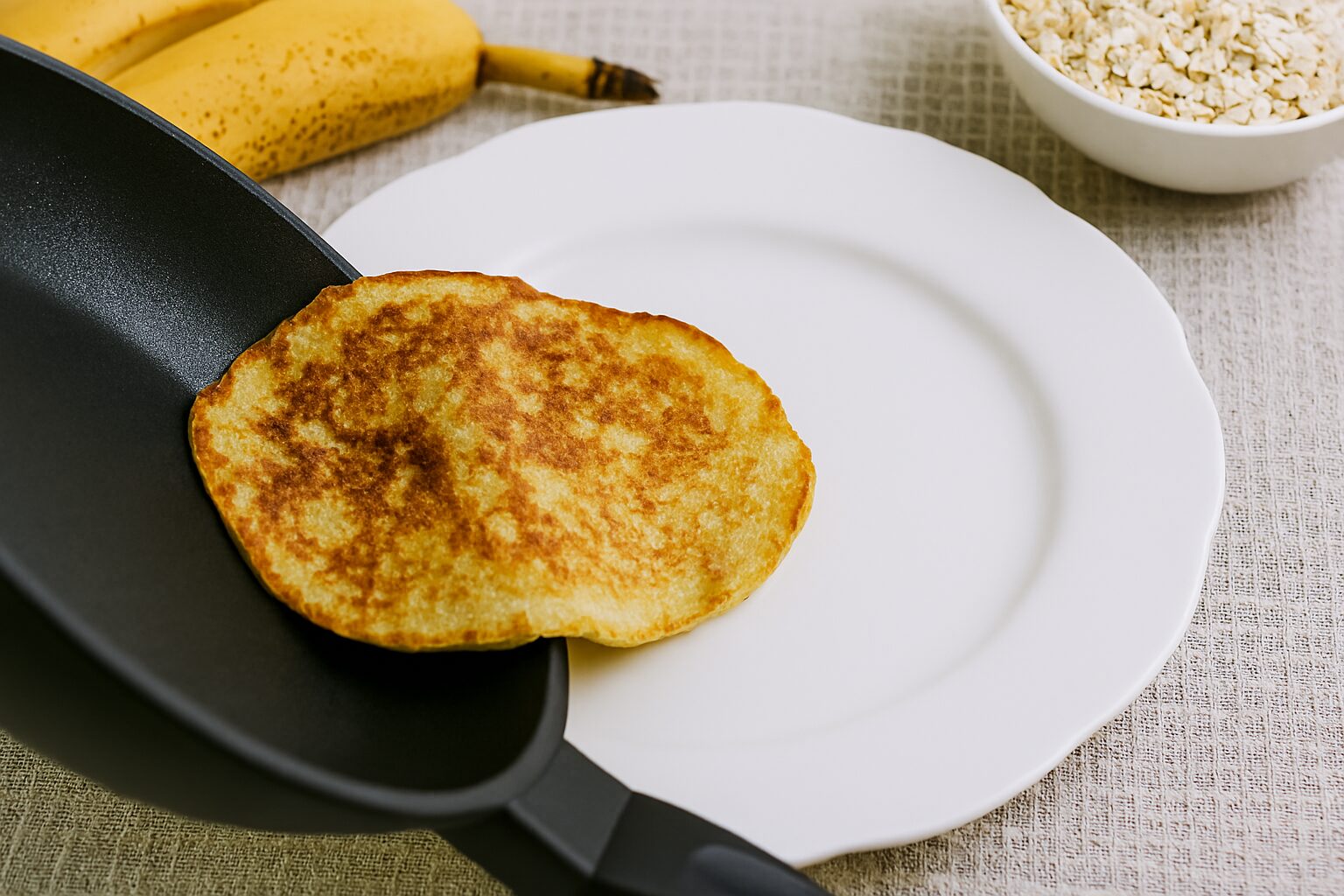Palačinka od banana, jaja i ovsenih pahuljica klizi iz tiganja pravo na tanjir