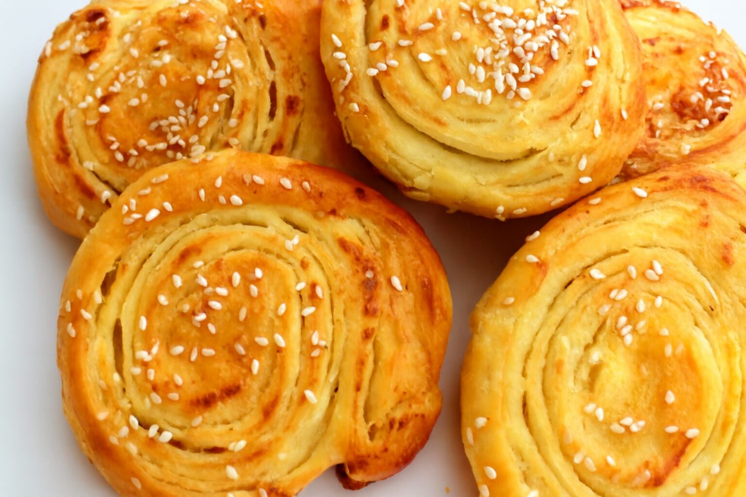 Pužići sa sirom posuti susamom, sveže pečeni i zlatno-hrskavi